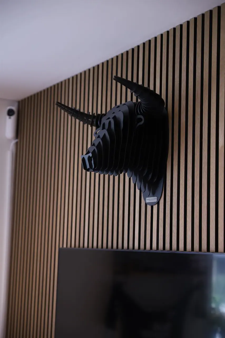 Bull-skulptur på trælistevæg